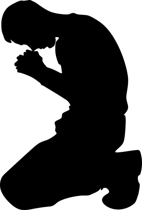 A silhouette of a man praying